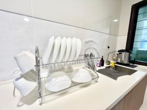 - un comptoir de cuisine avec des plaques blanches et un évier dans l'établissement O2 1-10Pax Pavilion Bukit Jalil 3Room Balcony WiFi, à Kuala Lumpur