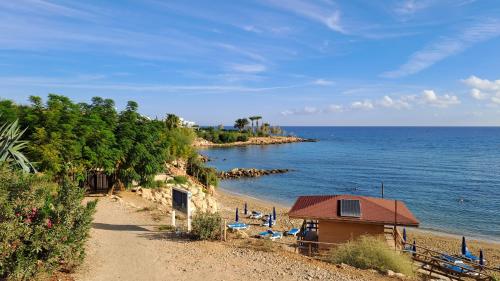 a beach with chairs and a building and the ocean at Relaxing Avra Villa in Paralimni
