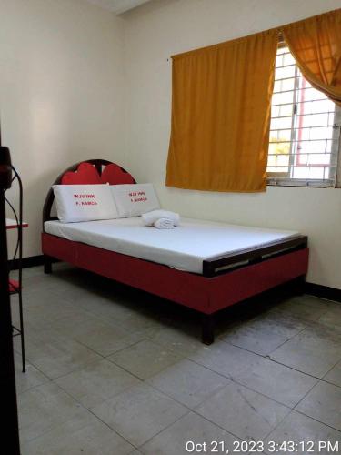 een bed in een kamer met een rood en wit matras bij WJV INN RAMOS in Cebu City