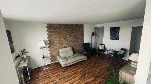 un soggiorno con divano e muro di mattoni di LES ESSARTS T2 a Bron