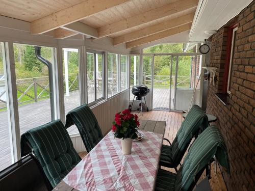 a screened in porch with a table and chairs at Spacious house with sauna 2 bathrooms and indoor pingis table! in Hestra