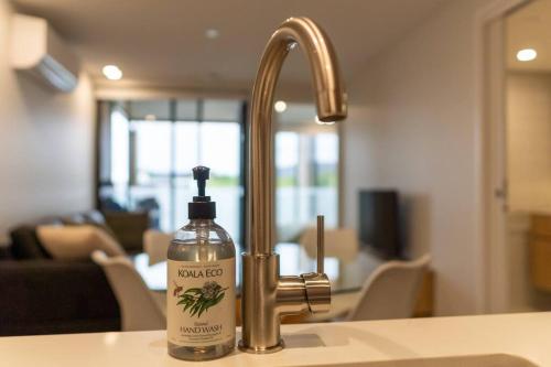 a bottle of soap sitting next to a kitchen sink at Stay on Northbourne Ave in Canberra