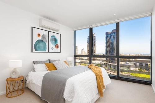 a bedroom with a large bed and a large window at Relax and Unwind by the Dock -Car park included- in Melbourne