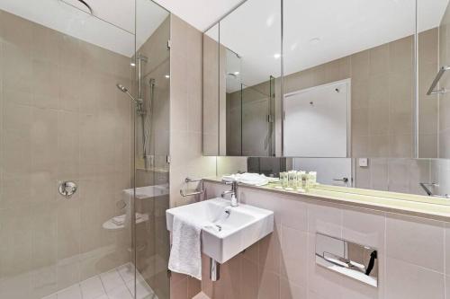 a bathroom with a sink and a shower and a mirror at Relax and Unwind by the Dock -Car park included- in Melbourne