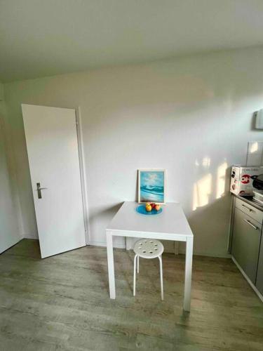 einen weißen Tisch mit einem Stuhl in der Küche in der Unterkunft Gemütliche 1,5 Wohn.: Komfort und Still in Bern
