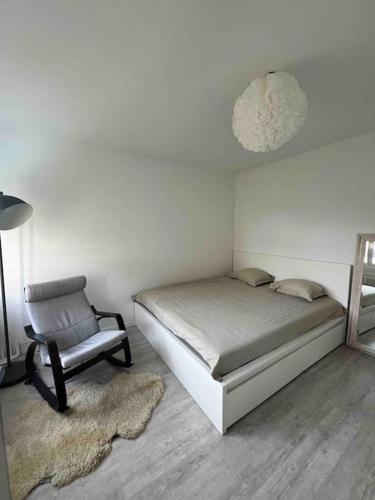 ein Schlafzimmer mit einem Bett, einem Stuhl und einem Teppich in der Unterkunft Gemütliche 1,5 Wohn.: Komfort und Still in Bern