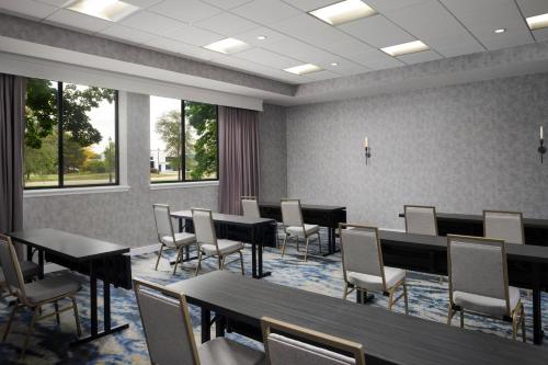 a conference room with tables and chairs and windows at Sheraton Grand Rapids Airport Hotel in Grand Rapids