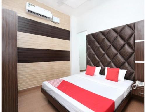 a bedroom with a bed with red pillows at Hotel Royal, Amritsar in Amritsar