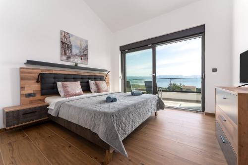 a bedroom with a bed and a large window at Villa Rosemary -semi-detached villa with a pool and a panoramic view, close to a sandy beach - by TRAVELER tourist agency Krk in Risika