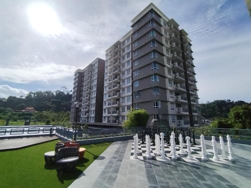 a large apartment building with a fountain in front of it at Double Nine Homestay - Sri Indah Condominium in Sandakan