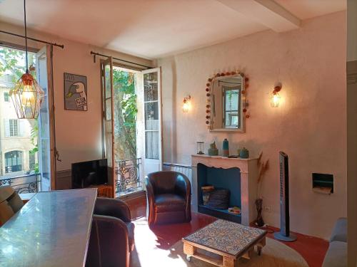 a living room with a table and a fireplace at La Vie de Bohème Avignon in Avignon