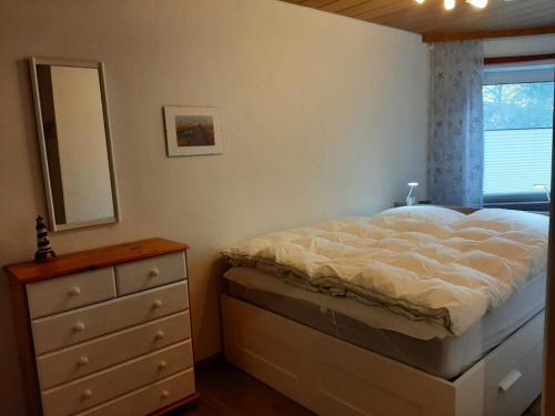 a bedroom with a bed and a dresser and a mirror at Fewo Am Deich 1 Appartment 30 in Sankt Peter-Ording