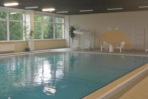 a large swimming pool with a table and chairs at Penthouse Brockenblick 381 in Braunlage