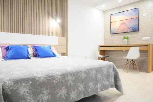 ein Schlafzimmer mit einem großen Bett mit blauen Kissen in der Unterkunft HAPPY ROOM in Granadilla de Abona