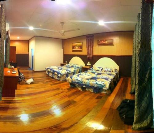 a room with three beds and a wooden floor at Mama's Chalet Pulau Perhentian Besar in Perhentian Island