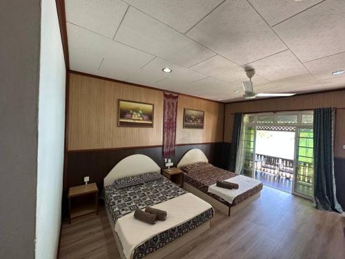 Zimmer mit 2 Betten in einem Zimmer mit Fenster in der Unterkunft Mama's Chalet Pulau Perhentian Besar in Kampong Pasir Hantu