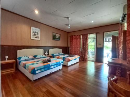 two beds in a room with wooden floors at Mama's Chalet Pulau Perhentian Besar in Kampong Pasir Hantu