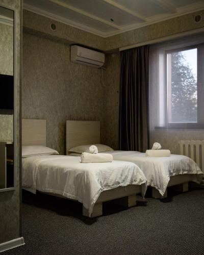 カラガンダにあるHotel "CONTINENT" halalのベッド2台と窓が備わるホテルルームです。
