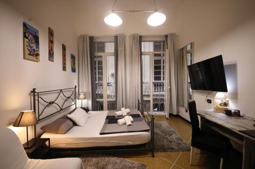 een slaapkamer met een bed, een bureau en een televisie bij Nik rooms in Genua