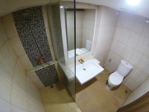 a bathroom with a toilet and a glass shower at Student Park 307 by We Stay in Seturan