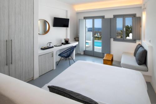 een hotelkamer met een bed, een bureau en een stoel bij Alunia Incognito Suites - Adults Only in Pirgos