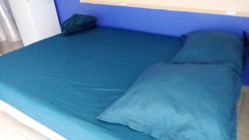 a blue bed with a blue sheet on it at Le Caferoom Club in Tsingoni