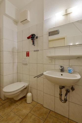 a bathroom with a toilet and a sink at Hotel Störtebeker in Graal-Müritz