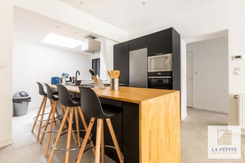 - une cuisine avec un comptoir en bois et des tabourets de bar dans l'établissement Atelier 46 - Appartement 2 chambres., à Valenciennes