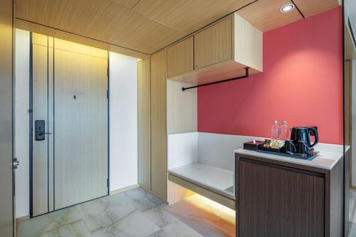 a kitchen with a counter and a red wall at Best Western Click Sathorn 11 Bangkok in Bangkok