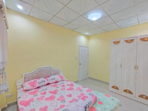 um quarto com uma cama cor-de-rosa com corações cor-de-rosa em แดดดี้ โฮมสเตย์ สัตหีบ em Ban Tao Than