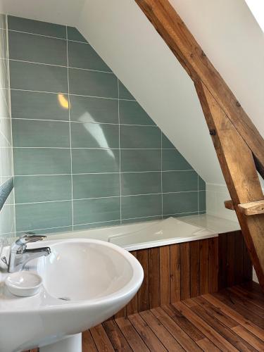 une salle de bain avec un lavabo et une baignoire dans l'établissement LE CLOS DES GRANGES, à Quiberville