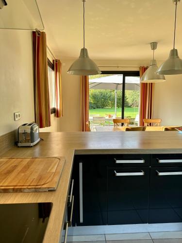 une cuisine avec un comptoir et une table dans l'établissement LE CLOS DES GRANGES, à Quiberville