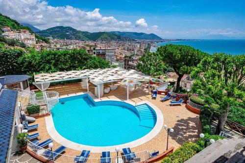 uma piscina com cadeiras e vista para o oceano em Hotel Villa Poseidon & Events em Salerno