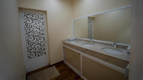 a bathroom with two sinks and a large mirror at استراحة الكثبان in Ḩawīyah