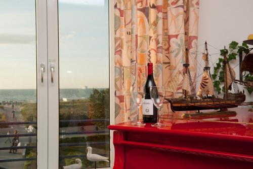 a bottle of wine and a model ship on a shelf at Villa Meerblick Warnemünde - Ferienwohnung mit Meerblick in erster Reihe zum Strand und Promenade in Warnemünde
