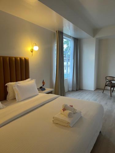 Hotel Pegasus Crown في شيلونغ: غرفة نوم بسرير ابيض كبير عليها مناشف
