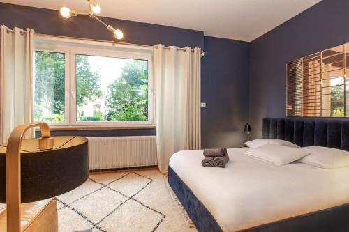 een slaapkamer met een groot bed en een raam bij La VILLA du Reims in Colmar