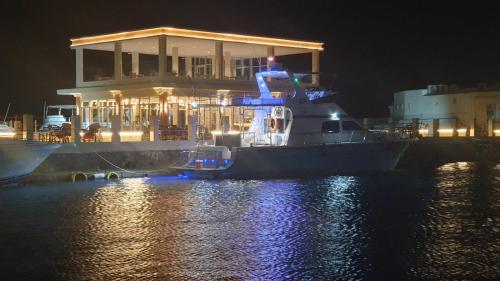 a large boat is docked in the water at night at منتجع شاطئ الدولفين للإيواء السياحي in Yanbu