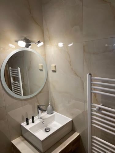 ein Badezimmer mit einem weißen Waschbecken und einem Spiegel in der Unterkunft Agapi in Orma