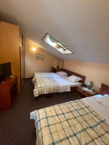 a hotel room with two beds and a television at Ada Apartments in Sarajevo