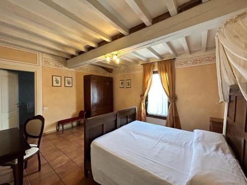 a bedroom with a bed and a table and a window at Hotel Airone in Piadena