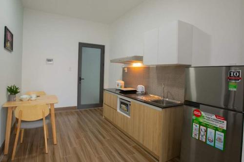 een keuken met een koelkast en een tafel. bij MNM apartment in Da Nang