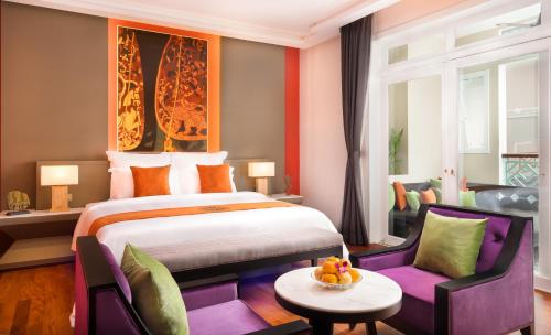 pokój hotelowy z łóżkiem, stołem i krzesłami w obiekcie Memoire Palace Resort & Spa w Siem Reap
