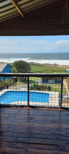 a balcony with a view of a swimming pool at Blue Space Beach Shack in Hibberdene