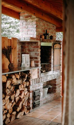 a brick fireplace with a pile of fire wood at Domowe Pielesze in Olszanica