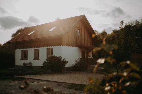 Biały dom z brązowym dachem w obiekcie Domowe Pielesze w mieście Olszanica