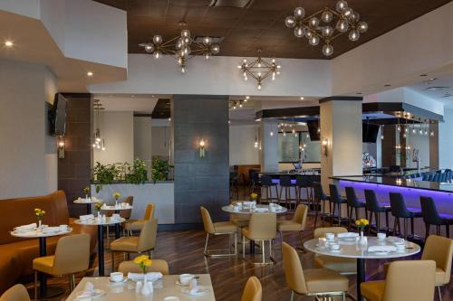 a restaurant with tables and chairs and a bar at Sheraton Edison in Edison