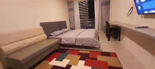 a bedroom with a bed and a couch and a television at SleepRest @ NTC in Nagoya