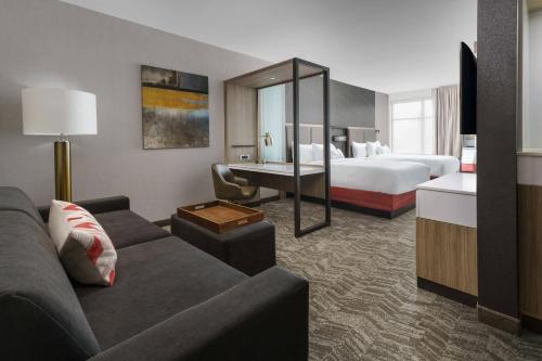 Cette chambre d'hôtel dispose d'un canapé, d'un lit et d'un bureau. dans l'établissement SpringHill Suites by Marriott Philadelphia West Chester/Exton, à Exton