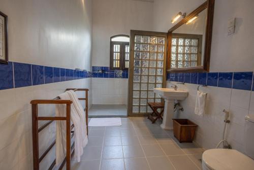 a blue and white bathroom with a sink and a toilet at South Point Abbey in Ahangama